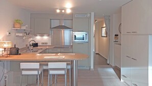 Una cucina moderna con isola centrale, forno a incasso e microonde.