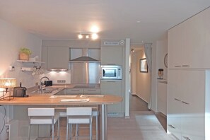 A modern kitchen with a central island, a built-in oven, and a microwave. - Coastal Family Escape in Knokke (KNOKKE - HEIST)