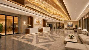 Eine Hotelhalle mit einer Rezeption, einer Treppe und einer Sitzecke.