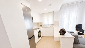 Eine moderne Küche mit weißen Schränken, einem Einbauofen und einem Kühlschrank.