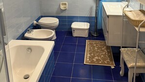 Un baño con bañera, inodoro, lavabo y zona de ducha.