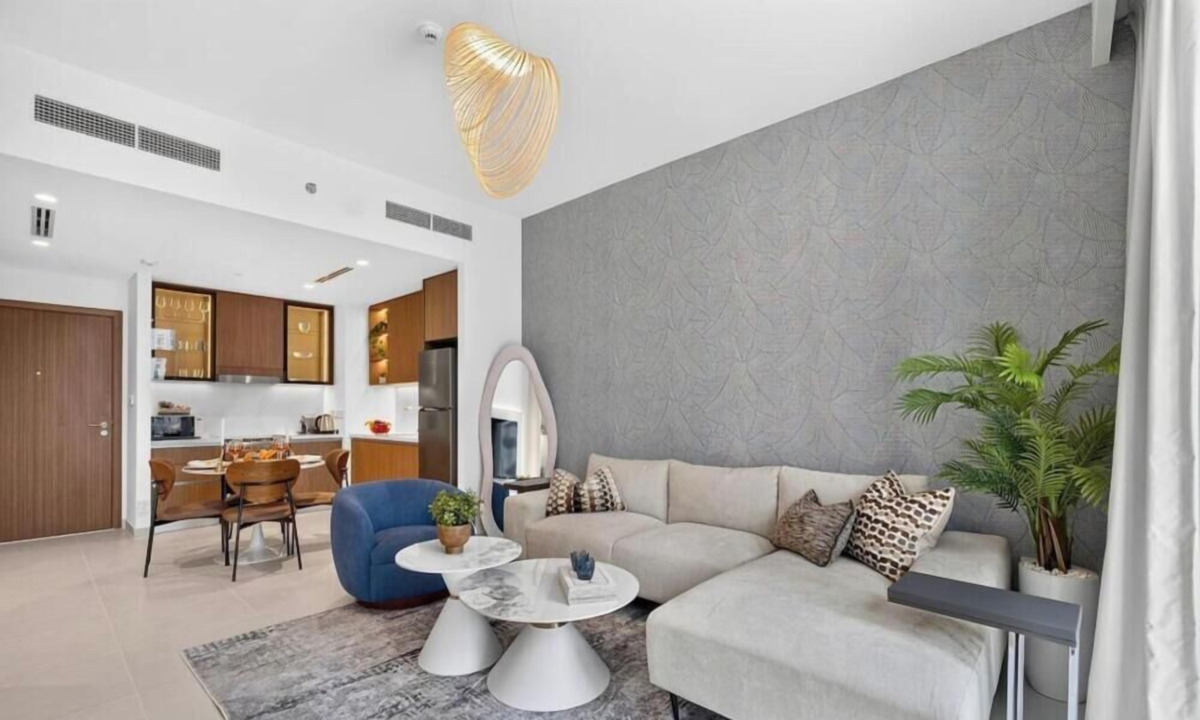 Un salon moderne comprenant un canapé, deux tables basses et un coin repas avec des chaises et une table.