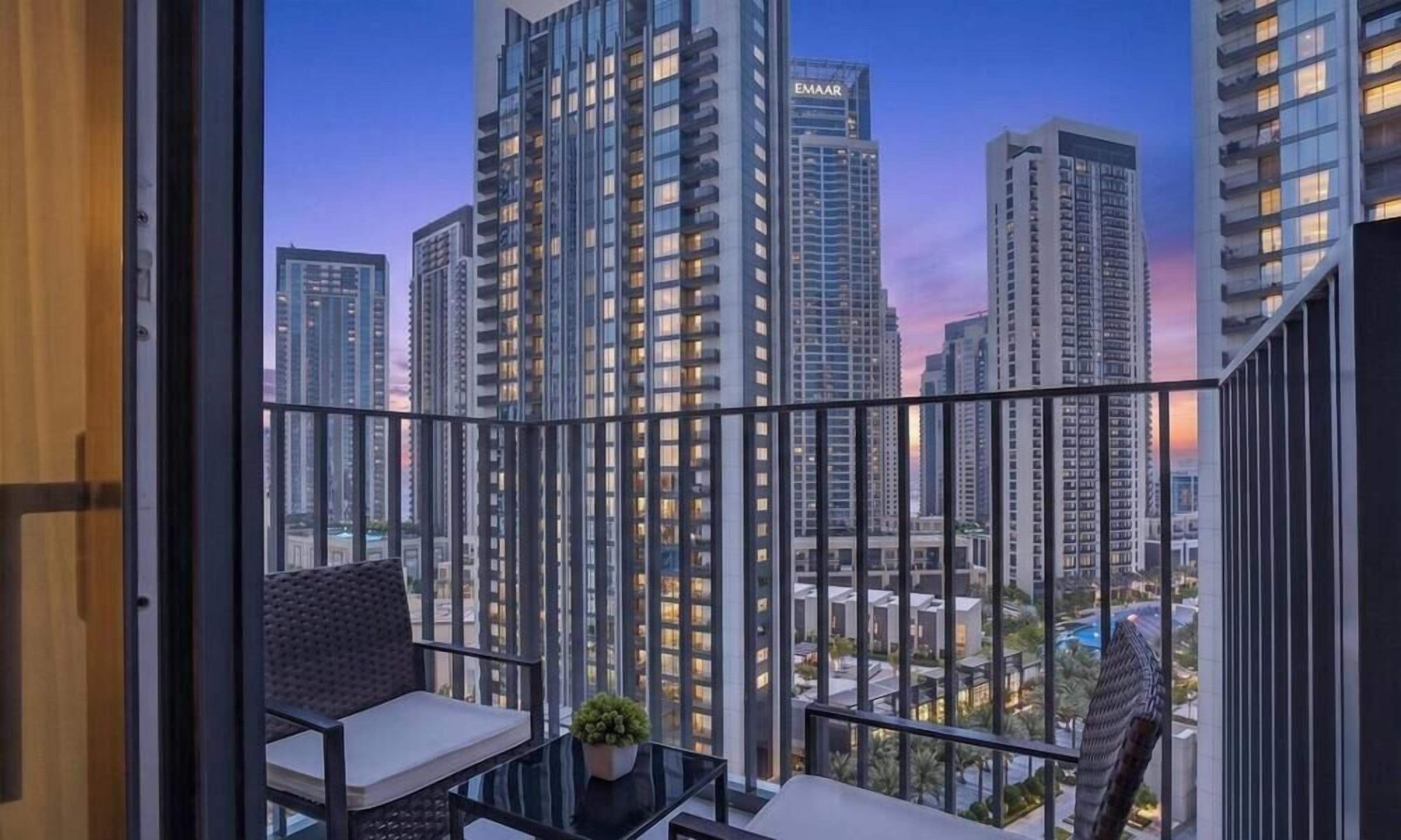 A balcony with a view of high-rise buildings during twilight.