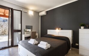 A modern bedroom with a bed, bedside table, and a desk with a chair. - Villa in Brucoli with 5 bedrooms sleeps 13 (Brucoli)