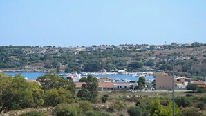 A coastal town with a marina, buildings, and hilly terrain. - Villa in Brucoli with 5 bedrooms sleeps 13 (Brucoli)