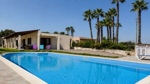 A swimming pool with a clear blue water surface, surrounded by a paved deck. - Villa in Brucoli with 5 bedrooms sleeps 13 (Brucoli)
