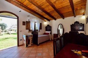 A room with a wooden ceiling, a bed with a headboard, a bedside table, a mirror, and a view of a garden. - Vacation Home in Arenella with 4 bedrooms sleeps 11 (Arenella)