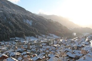 A snow-covered village with traditional buildings and a mountain backdrop. - La Favellaz: Exceptional panoramic view of the Aravis mountain range and the village (Le Grand-Bornand)