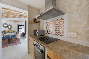 Une cuisine moderne dotée d’un four encastré, d’un four à micro-ondes et d’un grand îlot central.