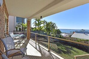 A balcony with a glass railing, outdoor furniture, and a view of the ocean. - Bella-Vista On Canomii (Nelson Bay)