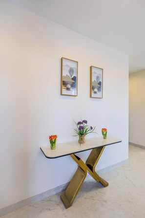 Ein modernes Interieur mit Marmorboden, einer weißen Wand und einem einzigartigen Tisch mit goldener Basis.
