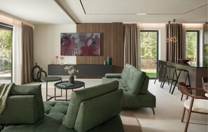 A modern living room with a green sofa, a coffee table, and a painting on the wall. - Luxurious home in Buje (Buje)