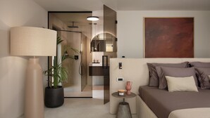 Een moderne hotelkamer met een bed, nachtkastje, lamp, potplant en een groot abstract schilderij aan de muur.