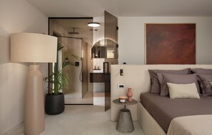 A modern hotel room with a bed, bedside table, lamp, potted plant, and a large abstract painting on the wall. - Luxurious home in Buje (Buje)