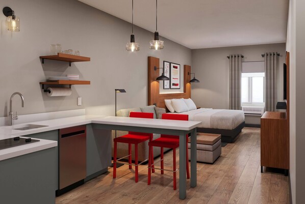A modern kitchen with a central island, bar stools, and pendant lighting. - Hawthorn Extended Stay by Wyndham Brownsville (Los Fresnos)