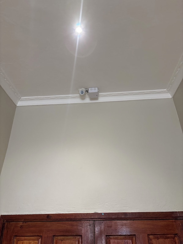 A ceiling with a recessed light fixture and a security camera.