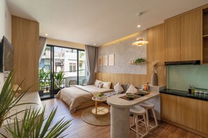 A modern apartment with a kitchenette, a dining area, a sofa, and a bed. - Babo Homestay 2 Da Nang (Da Nang)