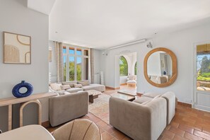 A spacious living room with a sectional sofa, a coffee table, and a large mirror.