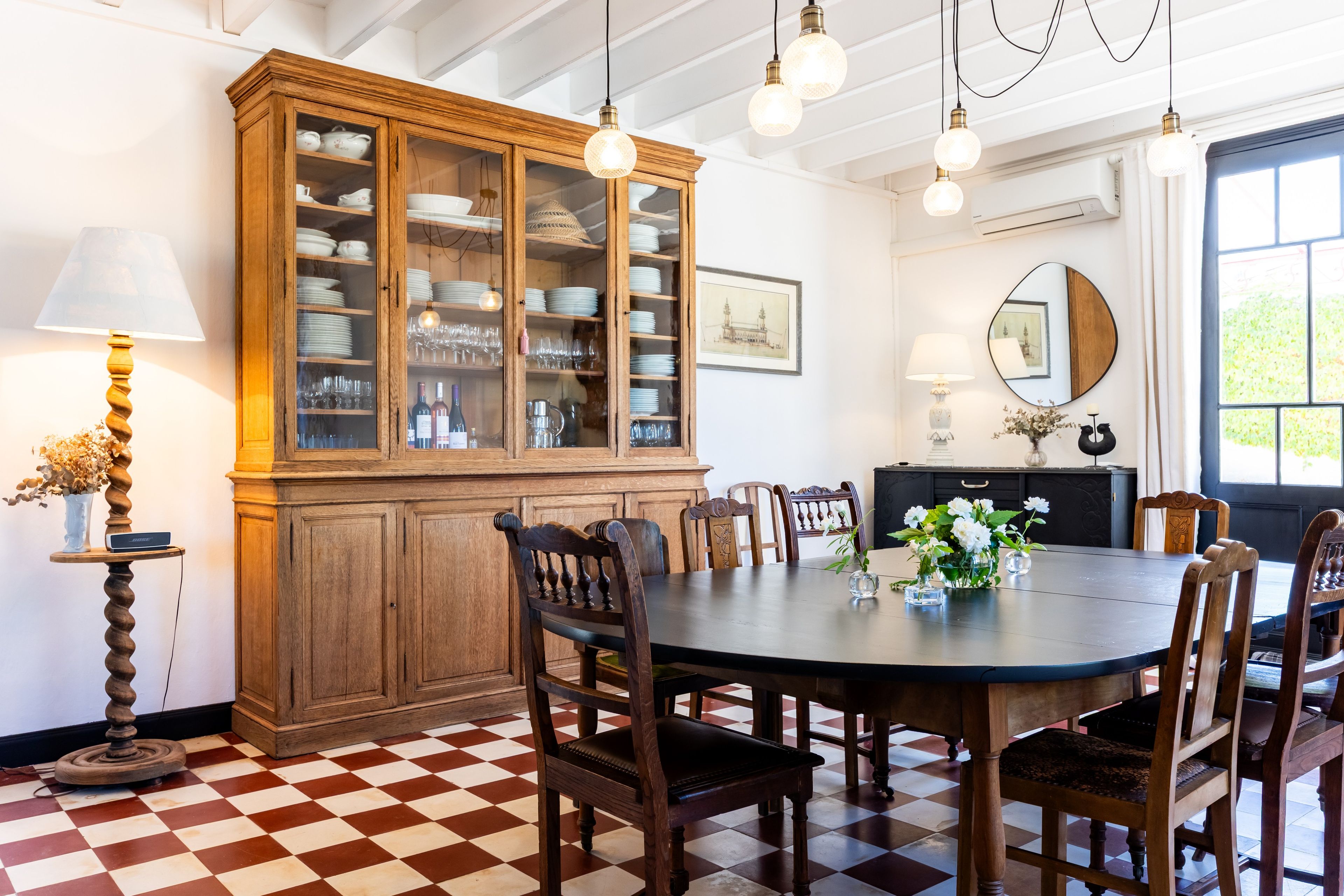 Un coin repas comprenant un grand buffet en bois, une table ronde et plusieurs chaises.