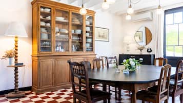 Un coin repas comprenant un grand buffet en bois, une table ronde et plusieurs chaises.