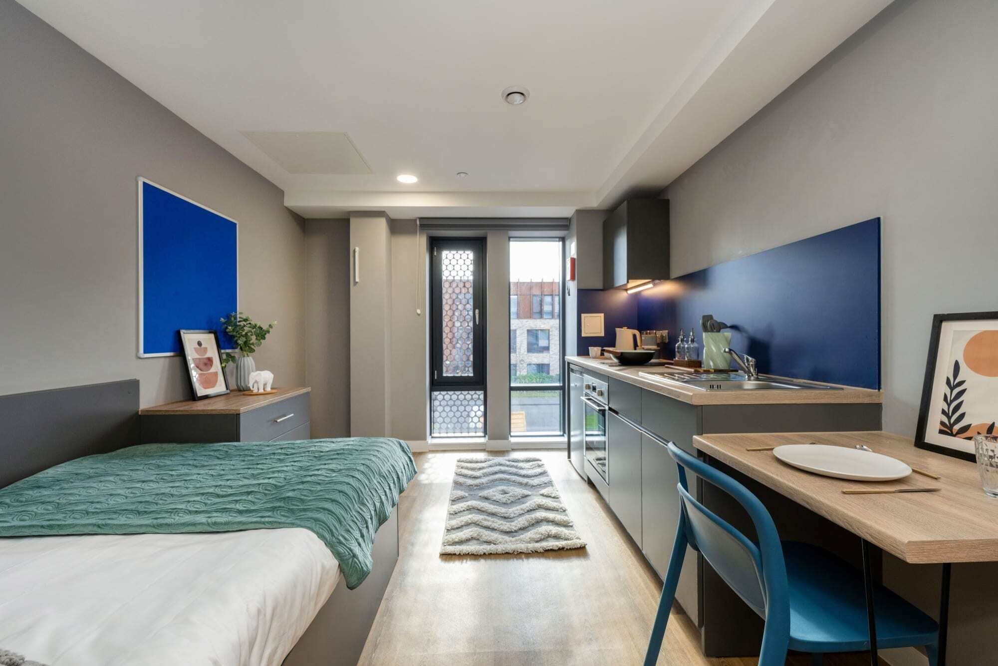 A modern bedroom with a bed, bedside table, and a view through a door.