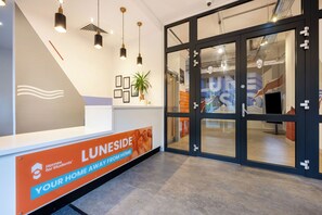 A reception area with a sign for Luneside, a sign for Homes for Students, and a large glass door leading to another room. - Student Only Luneside (Lancaster)