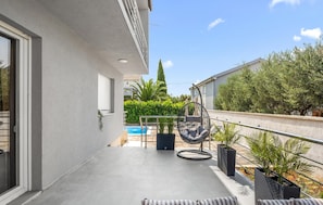 A balcony with a pool, outdoor furniture, and potted plants. - Stunning home in Kakma (Kakma)