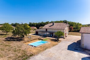Une propriété résidentielle dotée d’une piscine, d’un patio couvert et d’un garage séparé.