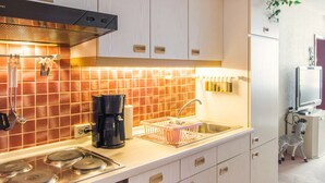 Una cocina moderna con estufa, cafetera y pileta.