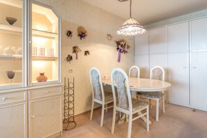 A dining area with a round table, white chairs, and a hanging light fixture. - Apartment "Auszeit in Hahnenklee" with Mountain View, Garden, Wi-Fi & Balcony (Goslar)