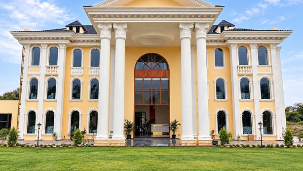 A large, yellow building with a symmetrical facade, multiple windows, and a central entrance.