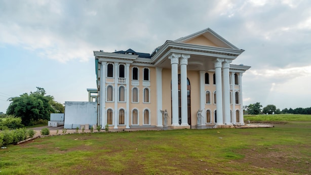 A large, stately building with a symmetrical facade, multiple columns, and a central entrance. - Shree Maa Vaishno Hotel & Resort (Ujjain)