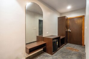 Un baño con un espejo grande, tocador de madera y una puerta.