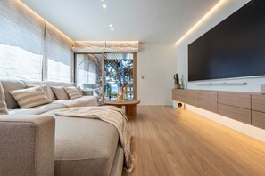 Quarto moderno com uma cama grande, televisão e vista para o exterior.