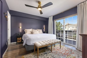 A bedroom with a large bed, a ceiling fan, a bench, a nightstand, and a view of the outside through a window. - 1 Car Garage | Gourmet Kitchen | On Bus Route (Steamboat Springs)