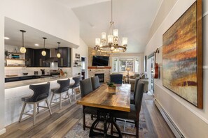 A modern kitchen with dark cabinets, a central island, and pendant lighting. - 1 Car Garage | Gourmet Kitchen | On Bus Route (Steamboat Springs)
