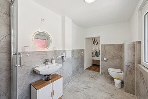 A modern bathroom with a white sink, mirror, and toilet. - Ramoni Apartments - Kinzing Oase - Alpirsbach (Alpirsbach)