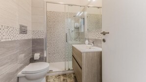 A bathroom with a toilet, a shower enclosure, and a vanity with a mirror. - THAT'S AMORE FIUMICINO AIRPORT  (Fiumicino)