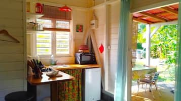 Une cuisine compacte équipée d’un réfrigérateur, d’un four à micro-ondes et d’une petite table à manger.