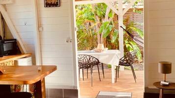 Quarto com área de refeições, uma mesa, cadeiras e vista para o exterior.