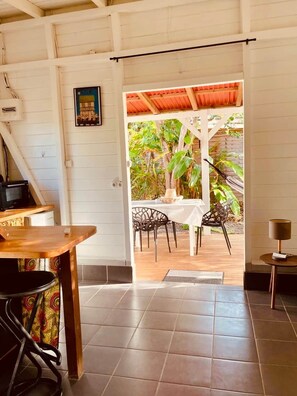 A room with a dining area, a table, chairs, and a view of the outdoors.