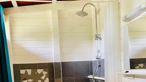 A bathroom with a shower, a sink, and a tiled wall. - Kaz Papaya, a Creole bungalow on Marie-Galante (Saint-Louis)