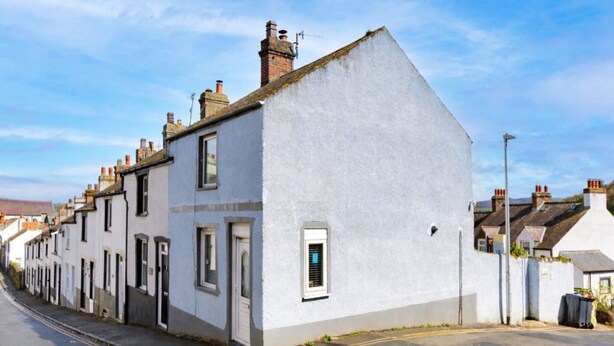 A residential street with white houses, a clear sky, and a road with a pedestrian crossing. - Holiday Cottage With Conwy Castle View (Conwy)