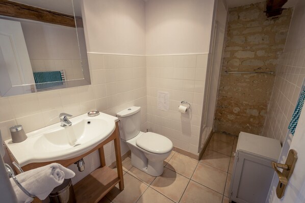 A bathroom with a sink, toilet, and shower.