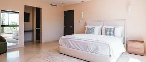 A bedroom with a bed, bedside tables, a window, and a door leading to another room.
