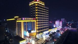 A multi-story hotel with illuminated signage and a parking lot. - Dongguan Jinzhenghe Hotel (Dongguan)