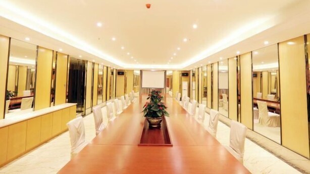 A conference room with a long table, chairs, and a potted plant. - Dongguan Jinzhenghe Hotel (Dongguan)