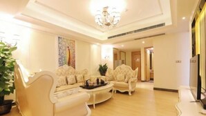 A spacious living room with a high ceiling, a chandelier, and a large painting on the wall. - Dongguan Jinzhenghe Hotel (Dongguan)
