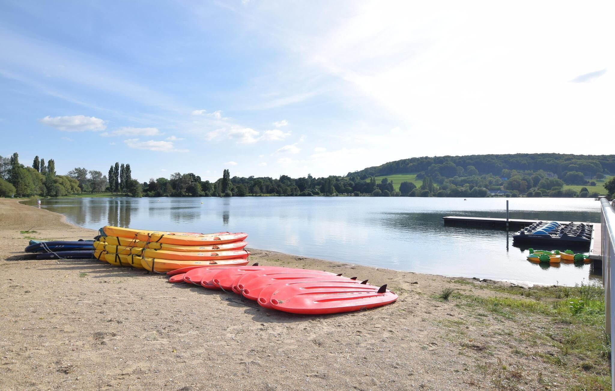 Un lago tranquilo con kayaks y un muelle.