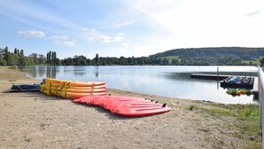Un lago tranquilo con kayaks y un muelle.